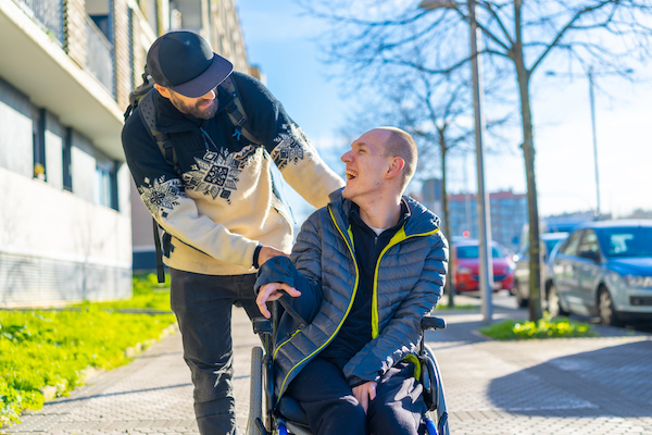 a-disabled-person-in-a-wheelchair-with-a-friend-smiling-handicapped-normality